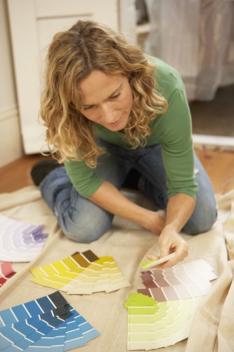 woman-kneeling-on-floor-looking-at-paint-sample-cards